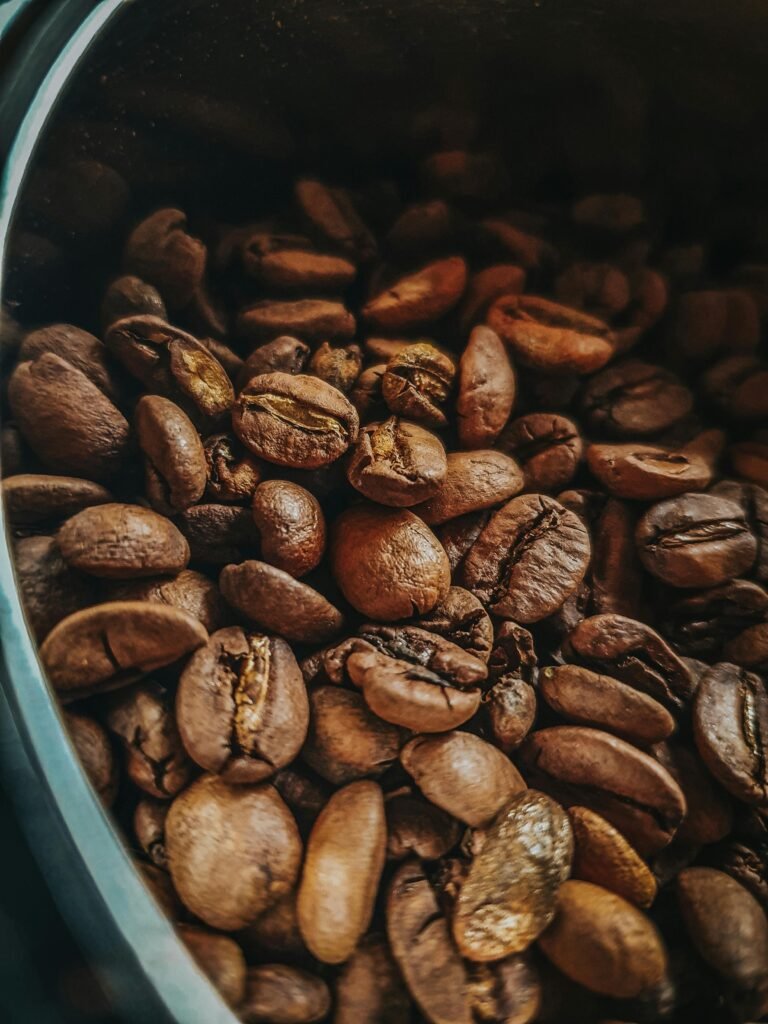 Detailed view of roasted coffee beans in a container in São Paulo, capturing rich textures and earthy tones.